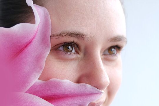 close up part of woman's face in flowers, beautiful girl 30 years old, human eyes looking to side, concept beauty and cosmetic procedures, vision examination, human brown health, plant pollen allergy