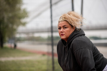 Hispanic middle aged obese woman resting after a run outdoors.