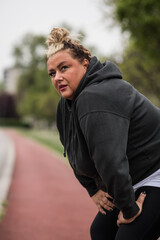 Plus size woman catching her breath after a long morning run.