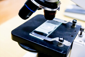 Old Soviet black microscope with a set of eyepieces on a white background.