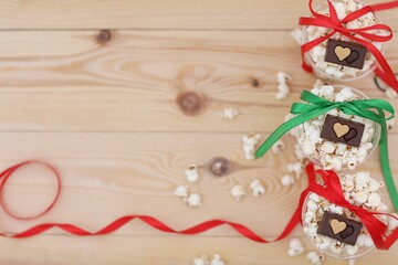 Popcorn in glasses on a wooden background, gift colored ribbons, holiday, day, celebration, greetings, wallpaper for presentations, photo, background, background image