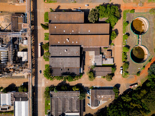 Aerial image of chemical industry. Large structure of pipelines and warehouses with movement of cargo trucks. Industry surrounded by vast vegetation and trees. Located in Brazil, city of Paulínia. © Paulo