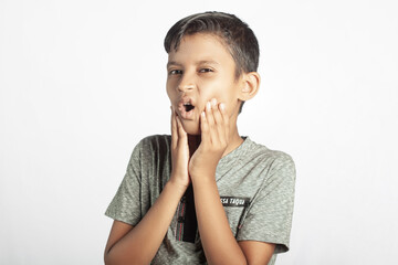 cute boy with toothache holding his tooth in white background