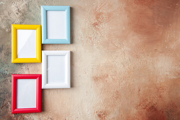 Front close view of colorful four photo frames on the right side hung on mix color wall with free...