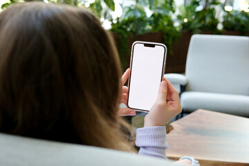 Young teen girl teenager looking at phone with brown hair white screen advertising app store in cafe