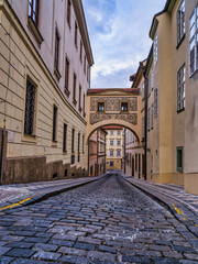 Prague paved street and historic buildings during a cloudy sky, Czech Republic