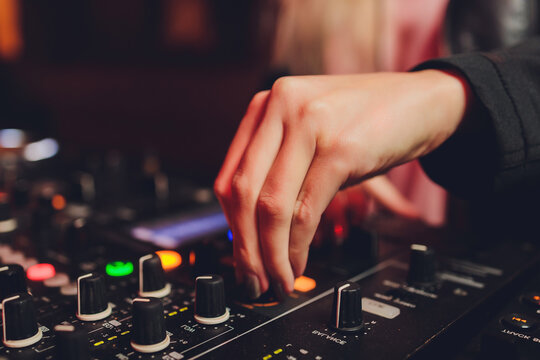 The DJ's hand on the mixer. Dj on the turntables. hand on a mixer close-up. Girl Man DJ at the mixer remote.