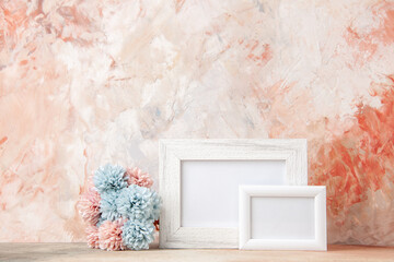 Top view of white small big empty wooden photo frames and flower on pastel colors background with free space