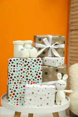 Baby shower party. Festive decor, booties, toy and gift boxes on white table