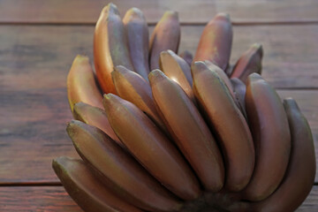 Tasty purple bananas on wooden table, closeup