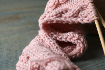 Fototapeta na wymiar Pink knitting and needles on wooden table, closeup