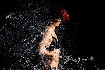 Tanned skin Asian woman in bikini poses in aqua studio. Splash Drops of water spread to body. Fun...