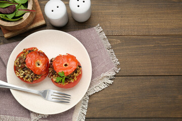 Delicious stuffed tomatoes with minced beef, bulgur and mushrooms served on wooden table, flat lay. Space for text