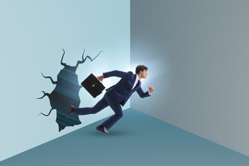 Businessman breaking through the wall