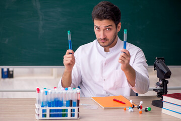Young male chemist sitting in the classroom
