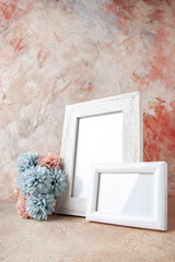 Vertical view of white empty wooden photo frame and flower on pastel colors background
