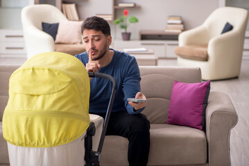 Young man looking after newborn at home