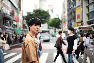 渋谷のスクランブル交差点を歩く若い男性