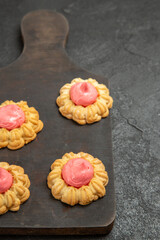 front view little sugar cookies with strawberry cream on dark grey background tea biscuit sugar cookies sweet cake