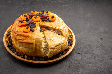 front view shakh plov delicious rice meal cooked inside round dough with raisins on grey background...