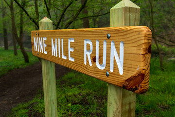 The Nile Mile Run sign, a creek in Frick Park in Pittsburgh, Pennsylvania, USA on a foggy spring morning