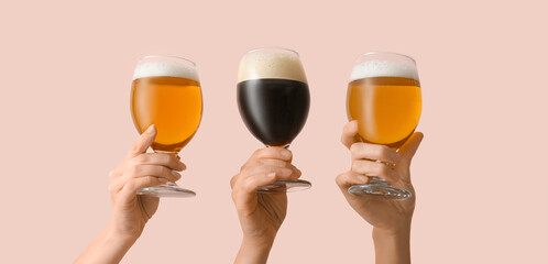Hands with glasses of beer on pink background - obrazy, fototapety, plakaty