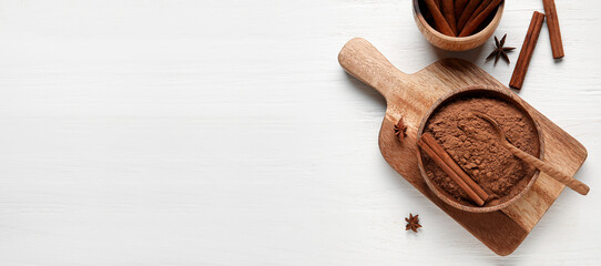 Bowl with cinnamon powder and sticks on white wooden background with space for text, top view