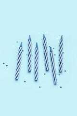 Birthday candles and glitter on blue background