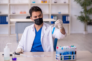 Young male chemist working at the lab