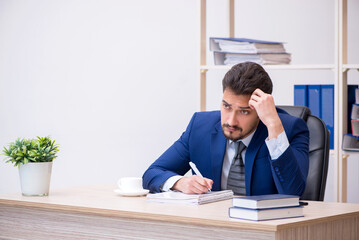 Young handsome employee working in the office