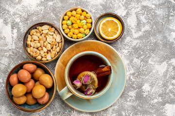 top view cup of tea with nuts and candies on white background nut tea candy snack sweet