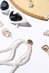 Jewelry with sunglasses and hat on white background, closeup