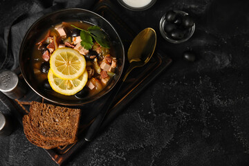 Bowl of tasty Hodgepodge soup with bread on dark background