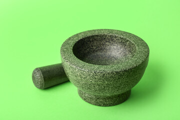 Mortar and pestle on green background