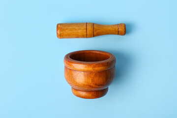 Wooden mortar and pestle on blue background