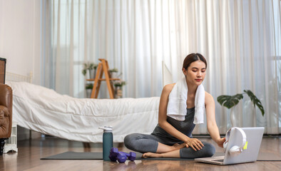 Portrait sport asian beauty body slim woman in sportswear sitting relax and girl practicing yoga and do fitness exercise with laptop computer in bedroom at home.Diet concept.Fitness and healthy