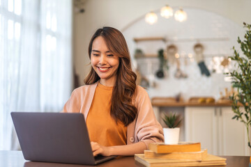 Young smiling asian woman relax using laptop conference work,learning education,study online,webinar podcast,creative woman looking at screen typing message with computer at home