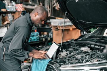 Experienced auto mechanics inspect car battery terminals and voltage to identify the cause of...