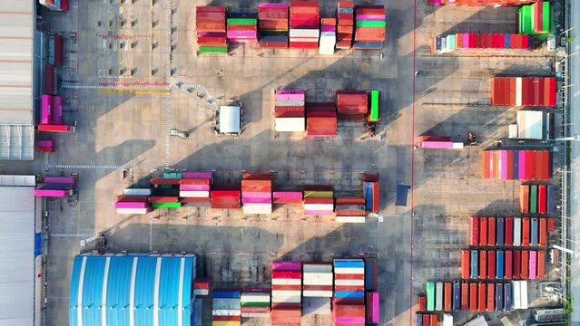 A containers are stacked in rows and columns, often several layers high, using specialized equipment such as container cranes, straddle carriers, or reach stackers. Transportation industry. 4K Drone
