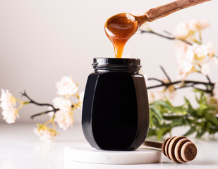 Manuka honey pouring into honey jar