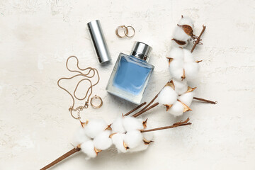 Composition with stylish female accessories, bottle of perfume, lipstick and cotton branch on light background