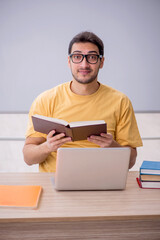 Young male student sitting in the classroom