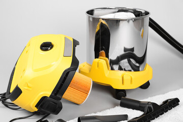 Vacuum cleaner with carpet on grey background