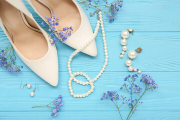 Composition with stylish female accessories, heels and gypsophila flowers on color wooden background