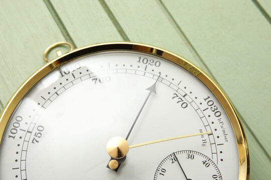 Aneroid barometer on green wooden background