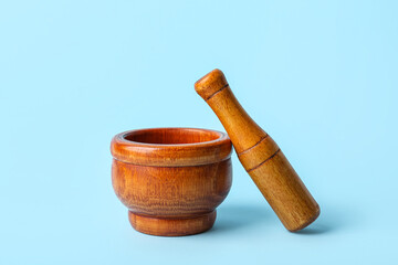 Wooden mortar and pestle on blue background