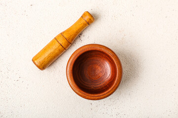 Wooden mortar and pestle on light background
