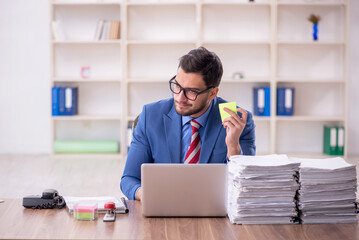 Young male employee unhappy with excessive work in the office