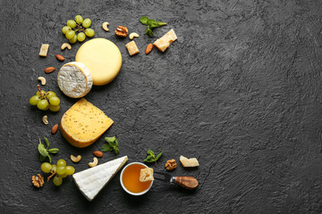 Obraz na płótnie Canvas Frame made of tasty cheese, nuts, grapes and honey on black background