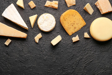 Fototapeta na wymiar Different types of tasty cheese on dark background